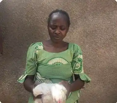 A Farmwin cluster farmer holding one of her broilers
